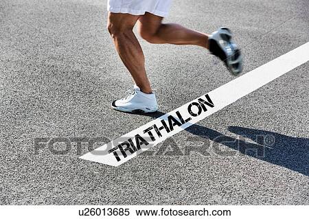 Stock Photography - Man running on white line with triathalon sign. Fotosearch