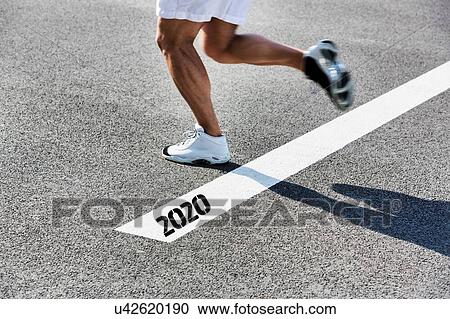 Stock Image - Man running on white line with year 2020 sign. Fotosearch