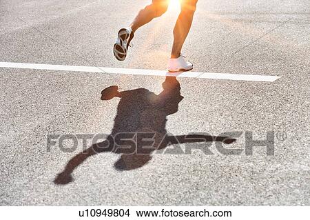 Picture - Man running on white starting line. Fotosearch