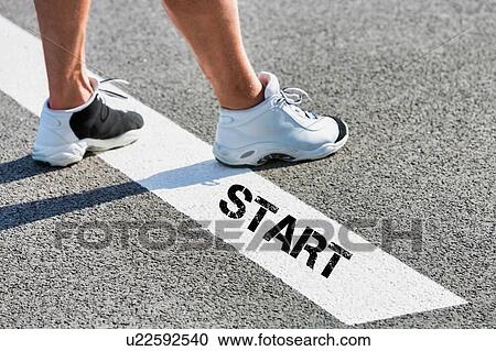Stock Image - Man standing on starting line. Fotosearch