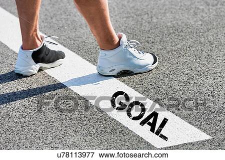Man standing on white line with goal sign View Large Photo Image Stock Photo - Man standing on white line with goal sign. Fotosearch
