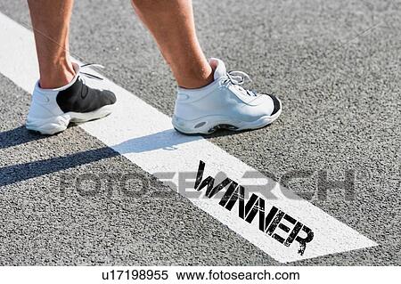 Stock Photography - Man standing on white line with winner sign. Fotosearch