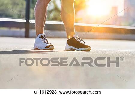 Stock Photo - Man standing while exercising in park. Fotosearch