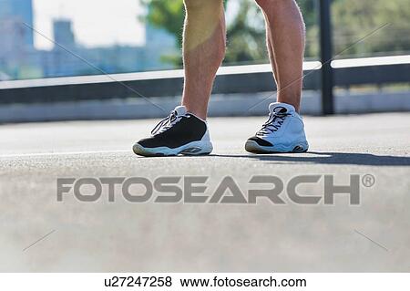 Stock Photo - Man standing while exercising in park. Fotosearch