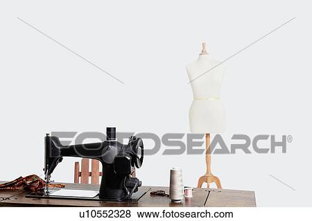 Mannequin and sewing machine with threads over gray background View Large Photo Image Stock Photo - Mannequin and sewing machine with threads over gray background. Fotosearch