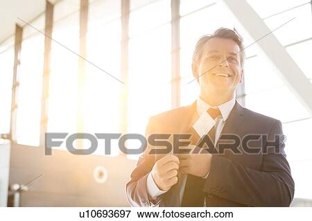 Mature attractive businessman taking out his passport from his suit in airport View Large Photo Image Stock Photo - Mature attractive businessman taking out his passport from his suit in airport. Fotosearch