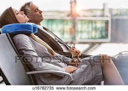 Mature businessman and young attractive businesswoman sleeping while waiting for boarding in their gate at airport View Large Photo Image Stock Photography - Mature businessman and young attractive businesswoman sleeping while waiting for boarding in their gate at airport. Fotosearch