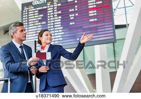 Mature businessman showing his boarding pass with the attractive airport staff View Large Photo Image Stock Image - Mature businessman showing his boarding pass with the attractive airport staff . Fotosearch