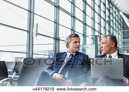 Mature businessman waiting for boarding in airport View Large Photo Image Stock Photo - Mature businessman waiting for boarding in airport. Fotosearch