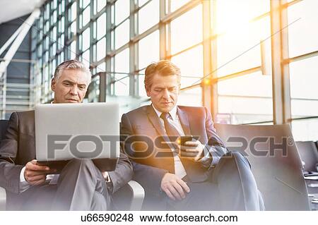 Stock Photo - Mature businessman waiting for boarding in airport. Fotosearch