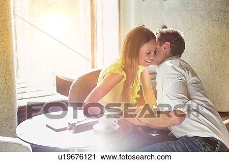 Mature businessman whispering on attractive woman ear while sitting in coffee shop View Large Photo Image Stock Image - Mature businessman whispering on attractive woman ear while sitting in coffee shop. Fotosearch