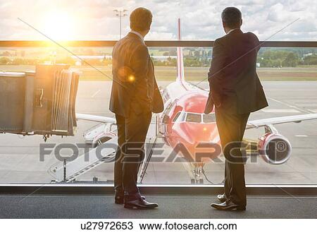 Mature businessmen standing while looking on the plane in airport View Large Photo Image Stock Image - Mature businessmen standing while looking on the plane in airport. Fotosearch
