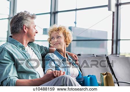 Mature couple sitting while waiting for their flight in airport View Large Photo Image Stock Photo - Mature couple sitting while waiting for their flight in airport. Fotosearch