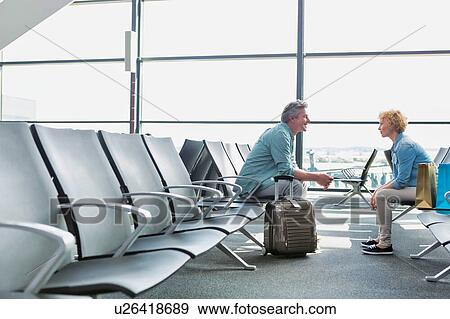 Mature couple sitting while waiting for their flight in airport View Large Photo Image Stock Photo - Mature couple sitting while waiting for their flight in airport. Fotosearch