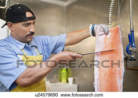 Mature fishmonger slicing salmon fish View Large Photo Image Stock Image - Mature fishmonger slicing salmon fish. Fotosearch