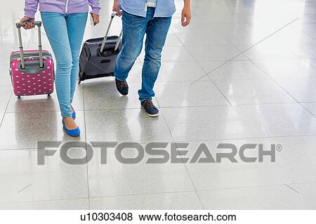 Mature man arriving with his daughter in airport looking for their pick up View Large Photo Image Stock Photo - Mature man arriving with his daughter in airport looking for their pick up . Fotosearch