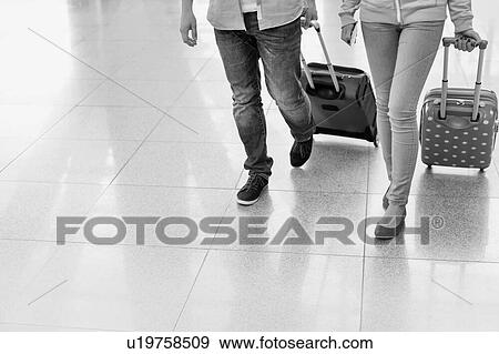 Mature man arriving with his daughter in airport looking for their pick up View Large Photo Image Stock Photo - Mature man arriving with his daughter in airport looking for their pick up . Fotosearch