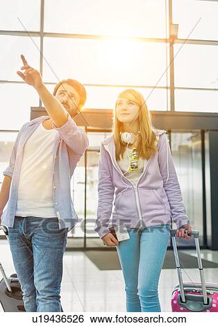 Mature man arriving with his daughter in airport looking for their pick up View Large Photo Image Stock Photograph - Mature man arriving with his daughter in airport looking for their pick up . Fotosearch