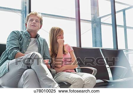 Mature man sitting with his daughter while waiting for their flight in airport View Large Photo Image Stock Photography - Mature man sitting with his daughter while waiting for their flight in airport. Fotosearch
