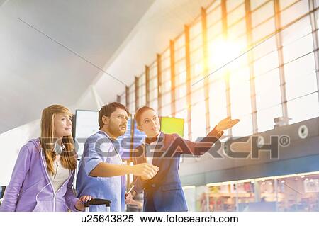 Stock Photography - Mature man traveling with her sister while asking for assistance with the airport staff . Fotosearch