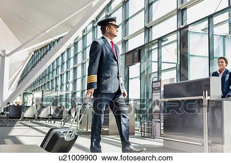 Mature pilot walking to enter the plane in boarding gate at airport View Large Photo Image Stock Image - Mature pilot walking to enter the plane in boarding gate at airport. Fotosearch