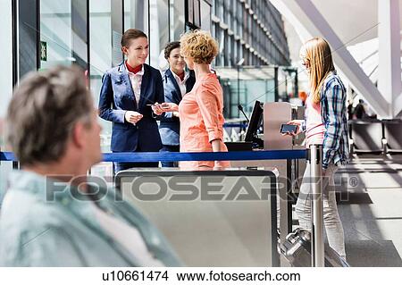 Mature woman on board giving her passport and boarding pass in airport View Large Photo Image Picture - Mature woman on board giving her passport and boarding pass in airport. Fotosearch