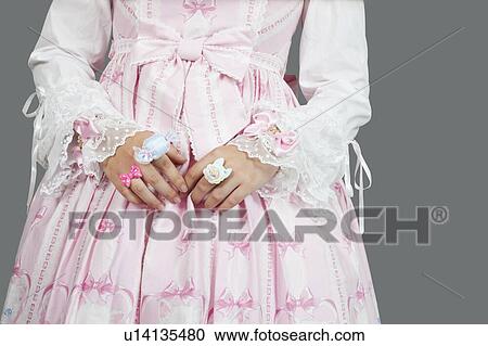 Mid section of young woman dressed as a doll over gray background View Large Photo Image Stock Image - Mid section of young woman dressed as a doll over gray background. Fotosearch