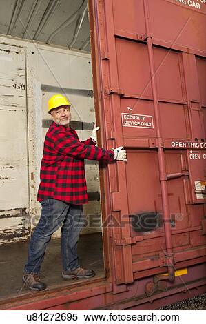 Middle aged worker opening metal railway carriage door View Large Photo Image Stock Photography - Middle aged worker opening metal railway carriage door. Fotosearch