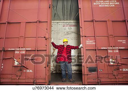 Middle Aged worker standing in industrial railway carriage View Large Photo Image Picture - Middle Aged worker standing in industrial railway carriage. Fotosearch