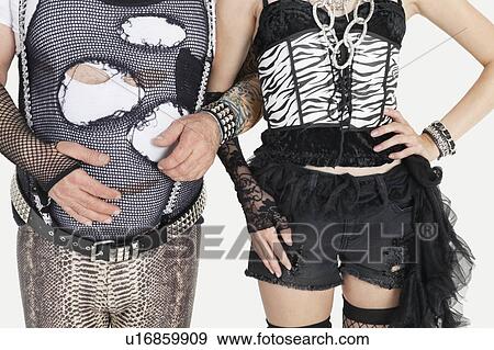 Midsection of punk man and woman standing with arm in arm View Large Photo Image Stock Photo - Midsection of punk man and woman standing with arm in arm. Fotosearch