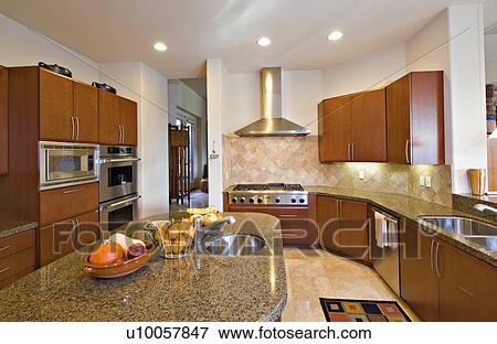 Stock Photo - Modern kitchen with fruits on counter in manor house. Fotosearch