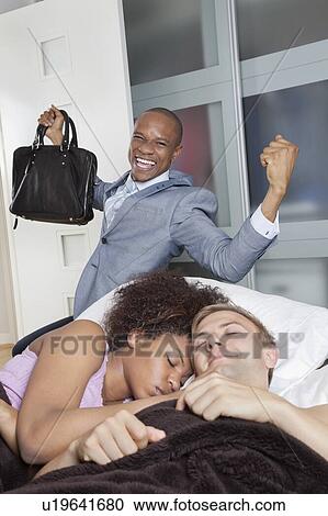 Multi-ethnic couple in bed with excited businessmen in background View Large Photo Image Stock Image - Multi-ethnic couple in bed with excited businessmen in background. Fotosearch