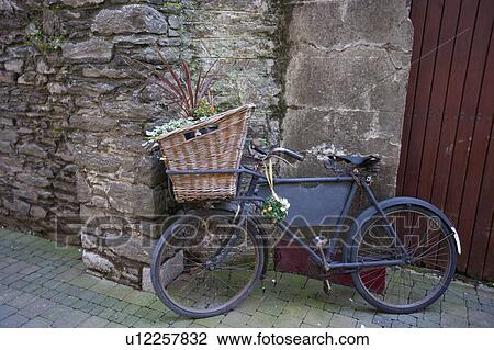 Stock Image - Old bicycle with basket and flowers. Fotosearch
