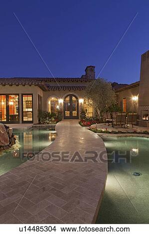 Picture - Open gate leading to luxury villa at dusk. Fotosearch