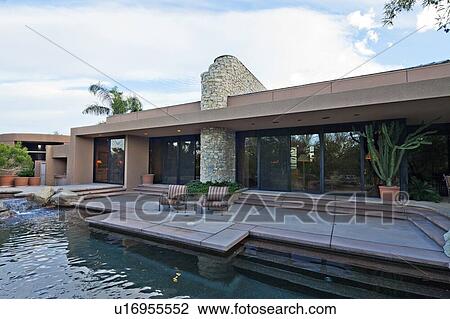 Stock Image - Outdoors chair in patio at poolside in luxury villa. Fotosearch
