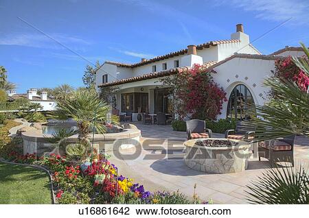 Stock Image - Outdoors seating furniture in patio of luxury manor house. Fotosearch