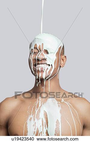 Paint falling on happy shirtless young man's head against gray background View Large Photo Image Stock Image - Paint falling on happy shirtless young man's head against gray background. Fotosearch