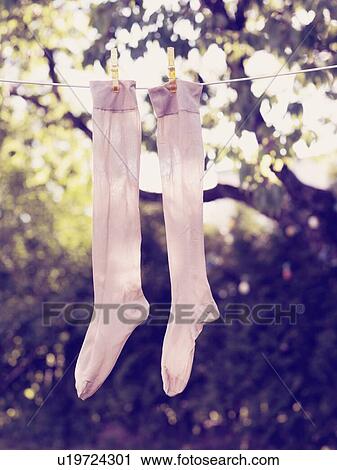 Stock Image - Pair of socks drying on clothesline. Fotosearch