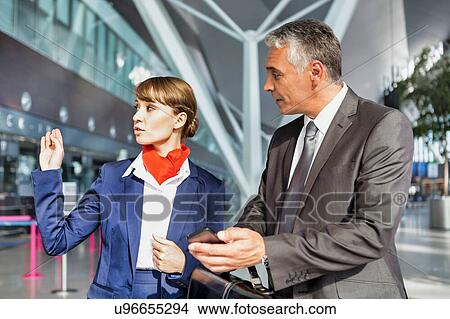 Picture - Passenger service agent assisting passenger to his gate in airport. Fotosearch