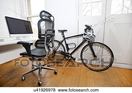 Stock Photo - PC, Desk and Bicycle inside an office. Fotosearch