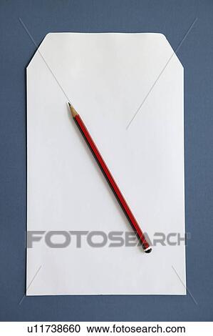 Stock Image - Pencil and blank paper over dark blue surface. Fotosearch