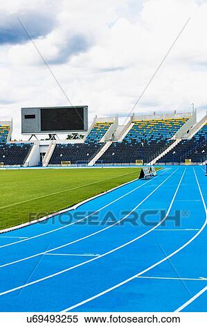 Stock Photography - Photo of blue tracking field on stadium . Fotosearch