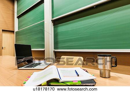 Photo of laptop on professor desk with tumbler and book View Large Photo Image Stock Image - Photo of laptop on professor desk with tumbler and book. Fotosearch