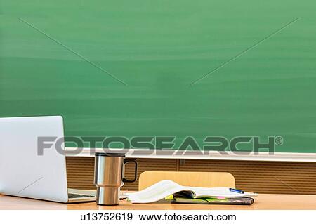 Photo of laptop on professor desk with tumbler and book against black board in classroom View Large Photo Image Stock Photo - Photo of laptop on professor desk with tumbler and book against black board in classroom. Fotosearch