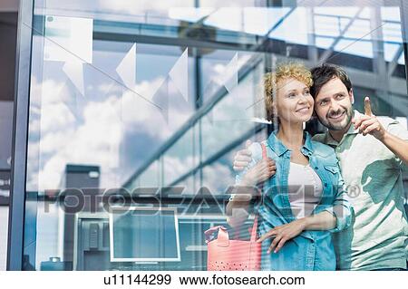 Stock Photo - Photo of mature couple looking through the window in airport. Fotosearch