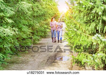 Photo of mature woman writing report on clipboard while walking with coworker in greenhouse View Large Photo Image Stock Image - Photo of mature woman writing report on clipboard while walking with coworker in greenhouse. Fotosearch