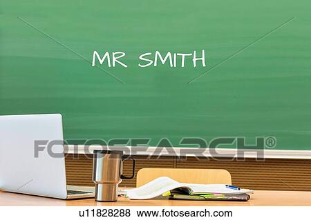 Stock Photo - Photo of professor desk in classroom with Mr Smith name written in black board. Fotosearch