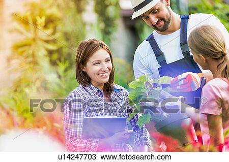 Stock Image - Photo of shop owner and garden staffs standing in the garden. Fotosearch