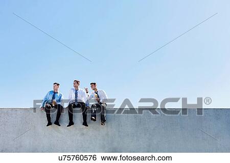 Stock Photograph - Photo of thoughtful businessmen sitting and relaxing on rooftop . Fotosearch
