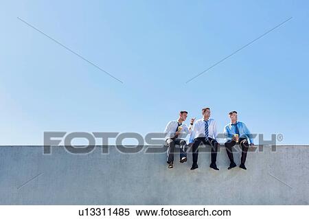 Photo of thoughtful businessmen sitting and relaxing on rooftop View Large Photo Image Stock Photography - Photo of thoughtful businessmen sitting and relaxing on rooftop . Fotosearch